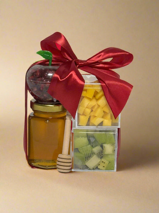 Gift set with honey, dried fruits, and a red ribbon on a light gold/brown background