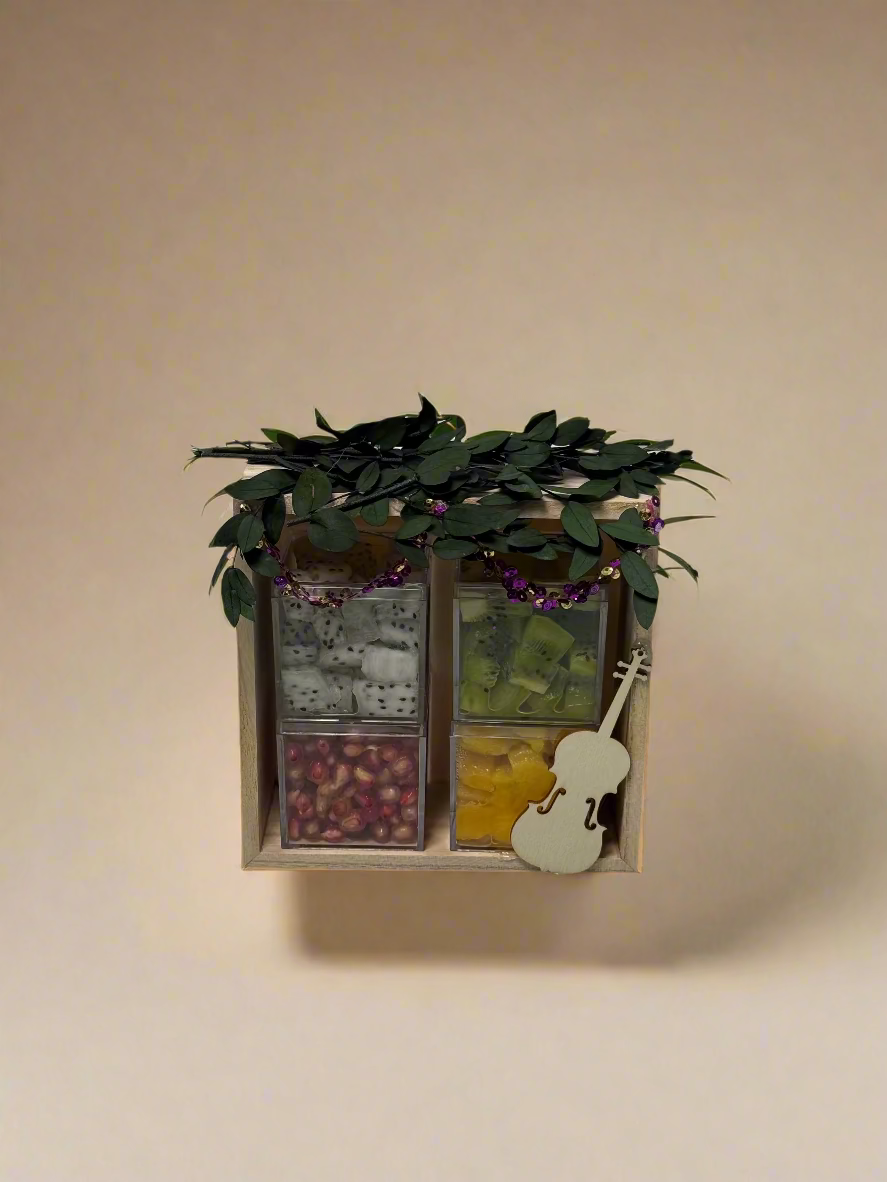 Decorative box with plant, small guitar, and colored blocks on a white background